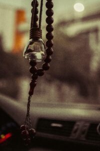 pexels-photo-7434504-7434504 Close-up of beads and decorative hanging in a car, evoking travel and spirituality.