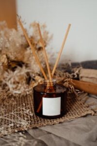 pexels-photo-7795656-7795656-1 Aromatic reed diffuser bottle with reeds on a rustic burlap and dry floral background.